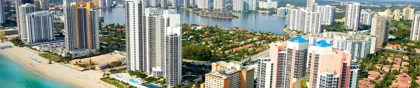 Aerial view of Miami's beachfront skyline with high-rise buildings, turquoise waters, and sandy beaches