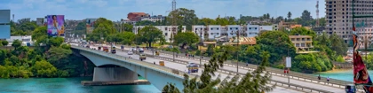 Nyali Bridge in Mombasa, Kenya, spanning turquoise waters with traffic and lush greenery on both sides