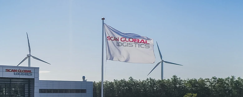 Scan Global Logistics flag flying outside headquarters with wind turbines in the background