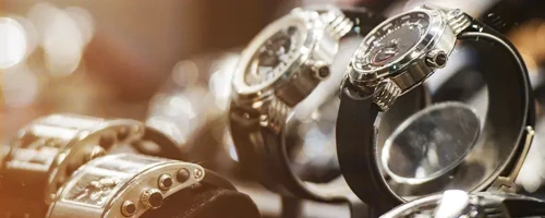 A selection of luxury wristwatches is arranged in a jewelry display case. The high-value items illustrate the need for secure, carefully managed transportation and specialized logistics solutions.