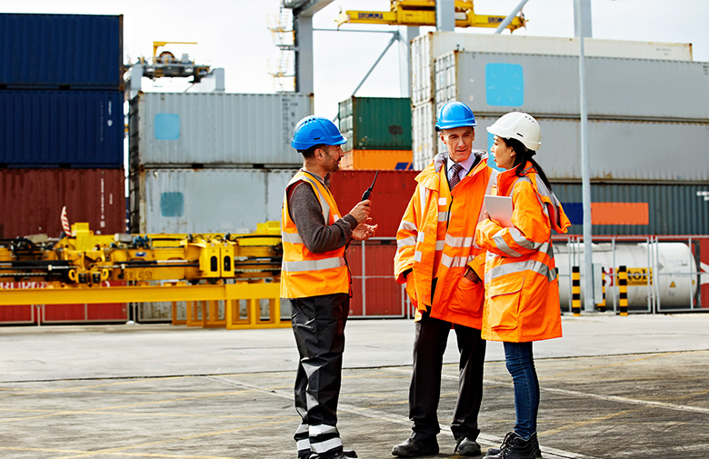 Group of logistics workers talking in a container terminal